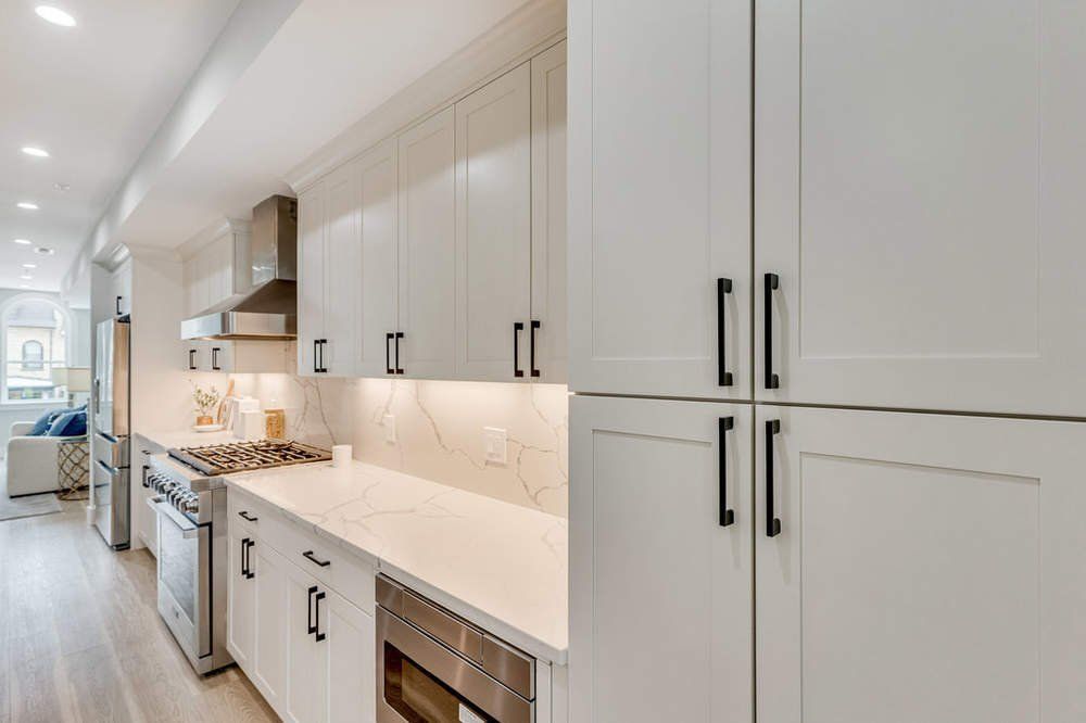 A kitchen with white cabinets and stainless steel appliances.