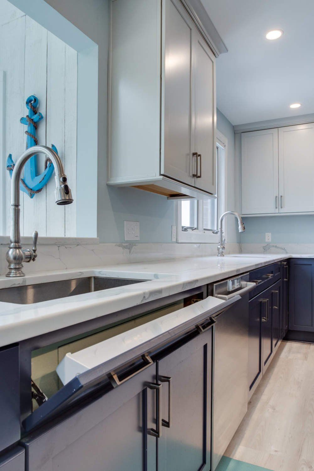 A kitchen with a sink , dishwasher , and anchor on the wall.