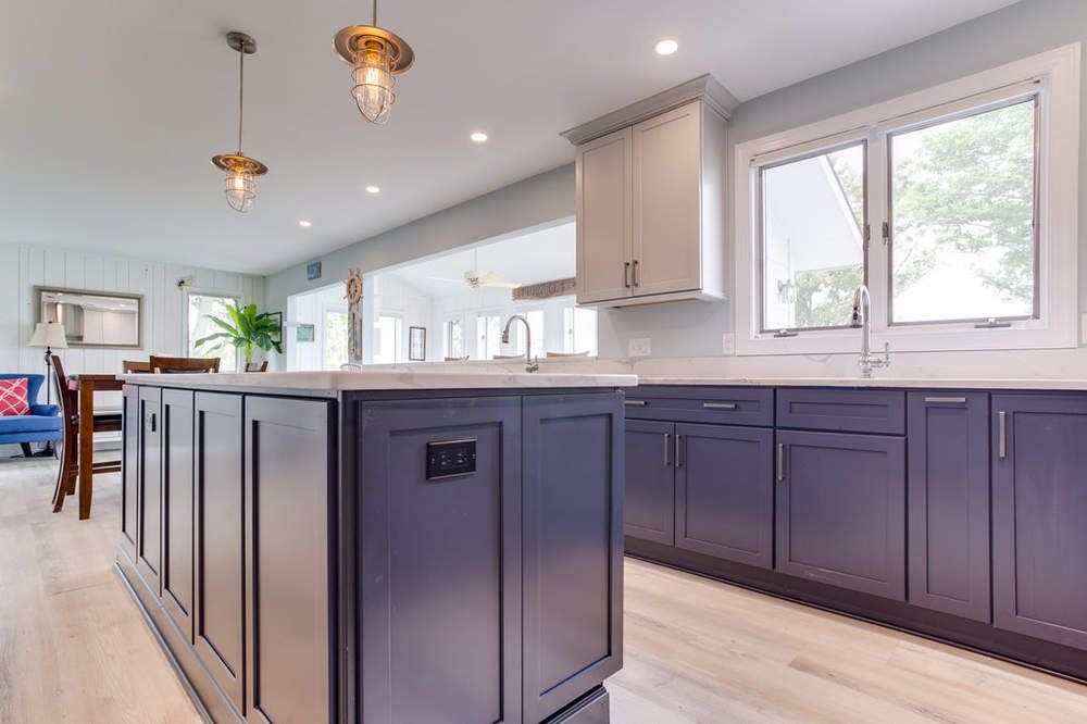 A kitchen with purple cabinets and a large island in the middle.