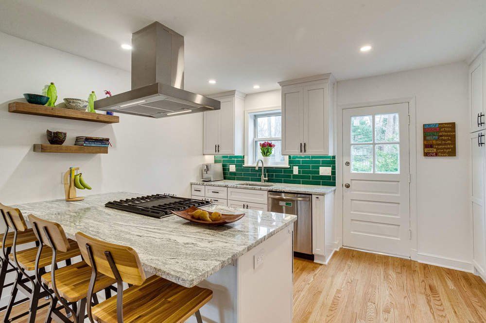 A kitchen with a large island and stainless steel appliances.