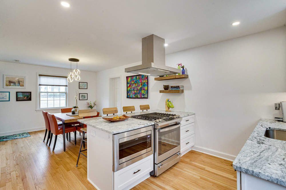 A kitchen with stainless steel appliances , granite counter tops , and a large island.