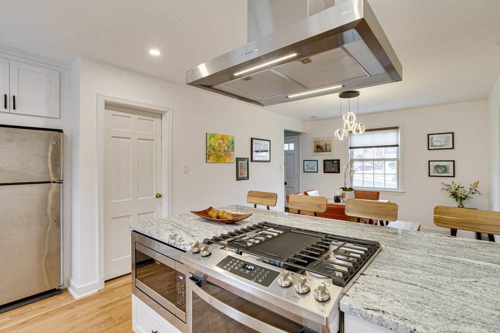 A kitchen with a stove top oven and a refrigerator.