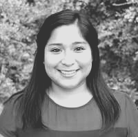 A woman is smiling in a black and white photo.