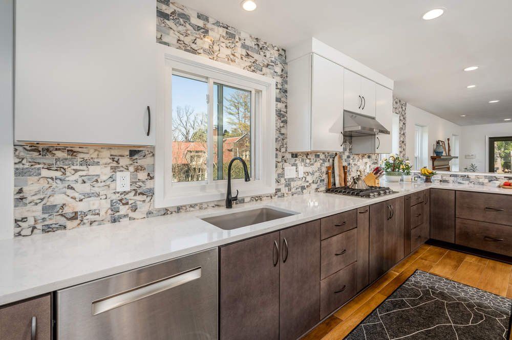 A kitchen with stainless steel appliances , a sink , and a window.