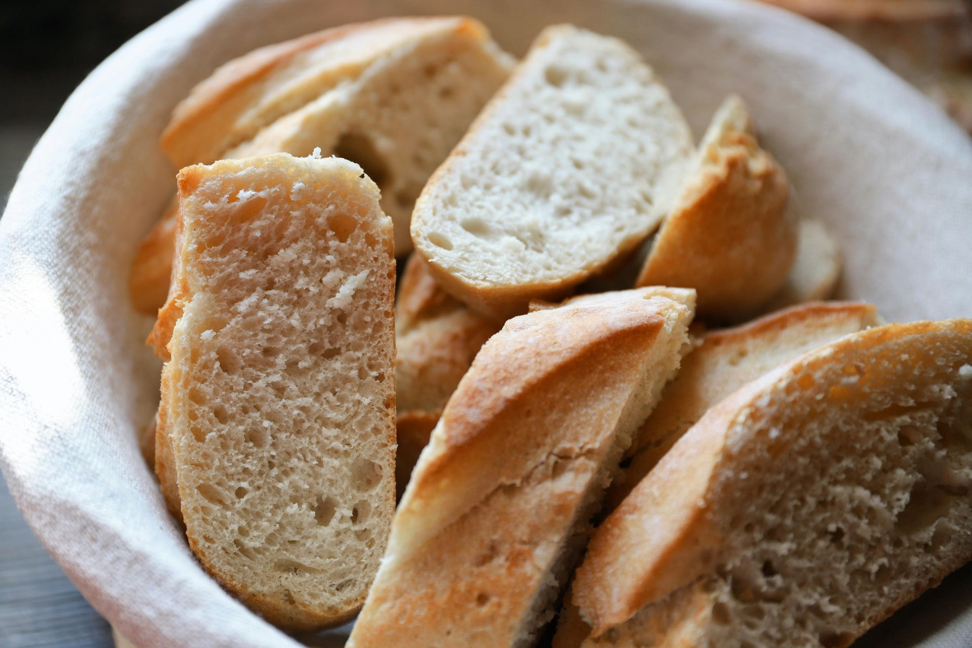 Sliced baguette bread in a white basket.