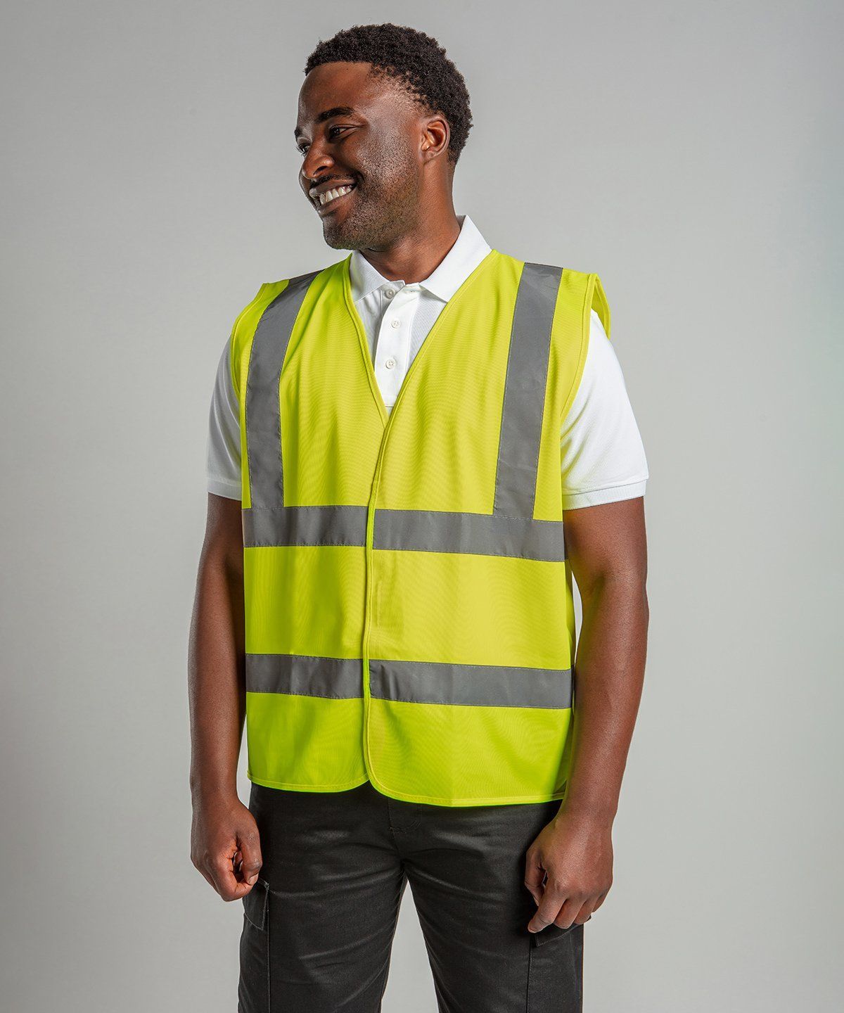WhiteLodge Man wearing a high-visibility yellow safety vest over a white polo shirt, smiling.