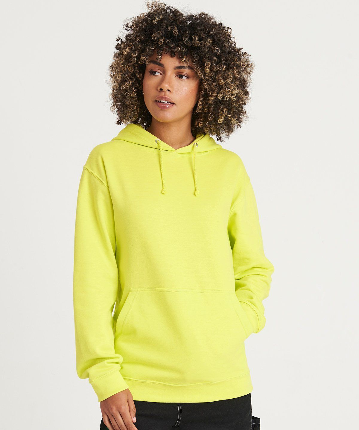 WhiteLodge Woman in a bright yellow hoodie, hands in the front pocket, posing in front of a white background.