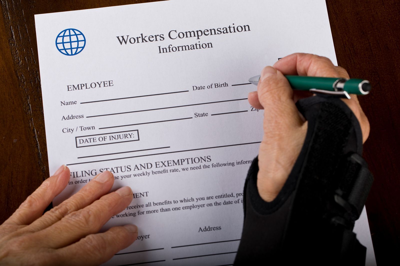 A person is filling out a workers compensation information form