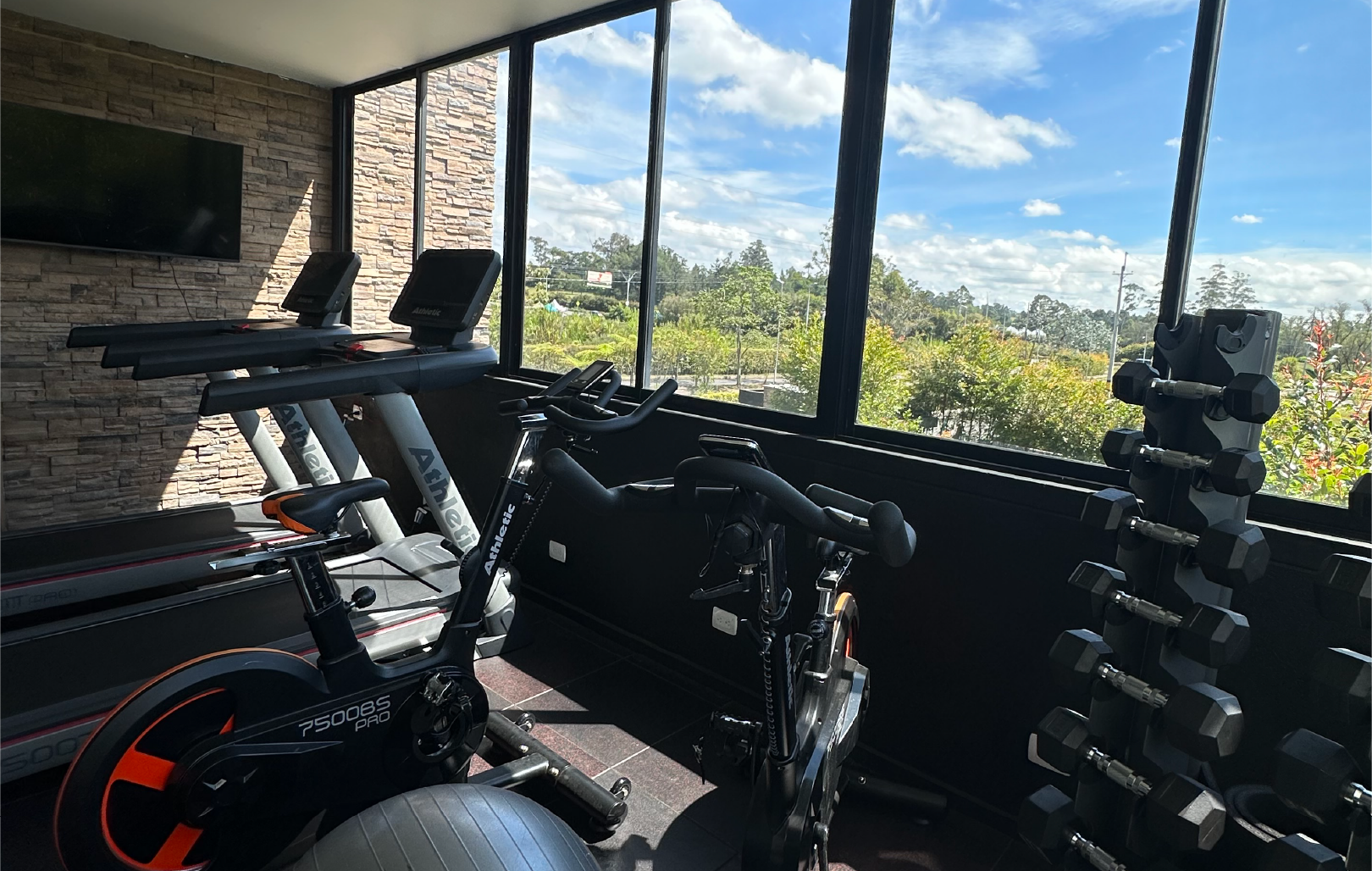 Un gimnasio con cinta de correr, bicicleta estática y mancuernas  hotel Lagoon Llanogrande.