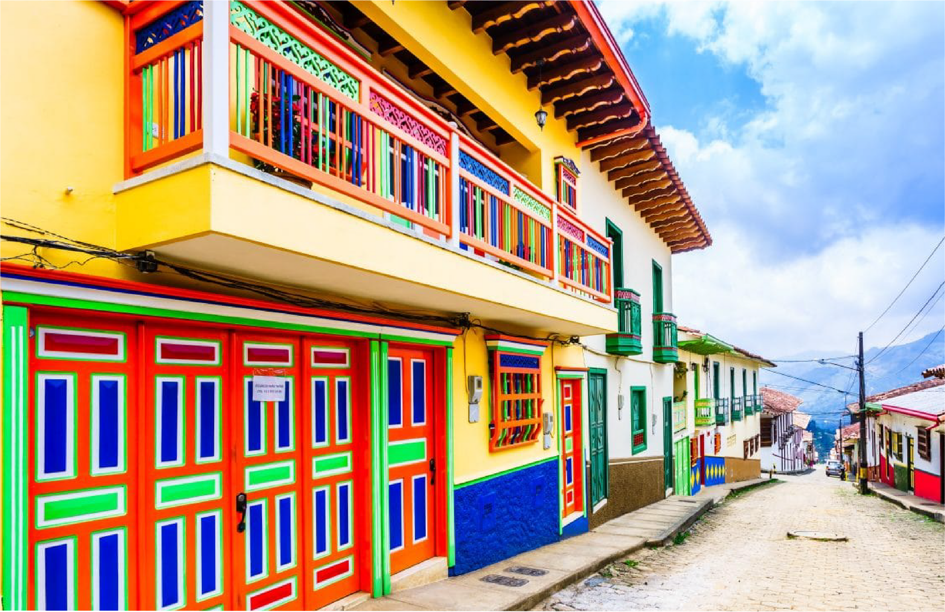 Un edificio colorido con un balcón en el costado Rionegro.