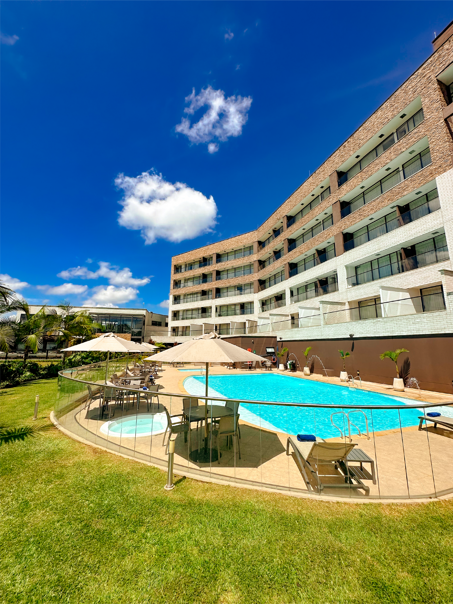 Un gran hotel con una gran piscina frente a él.