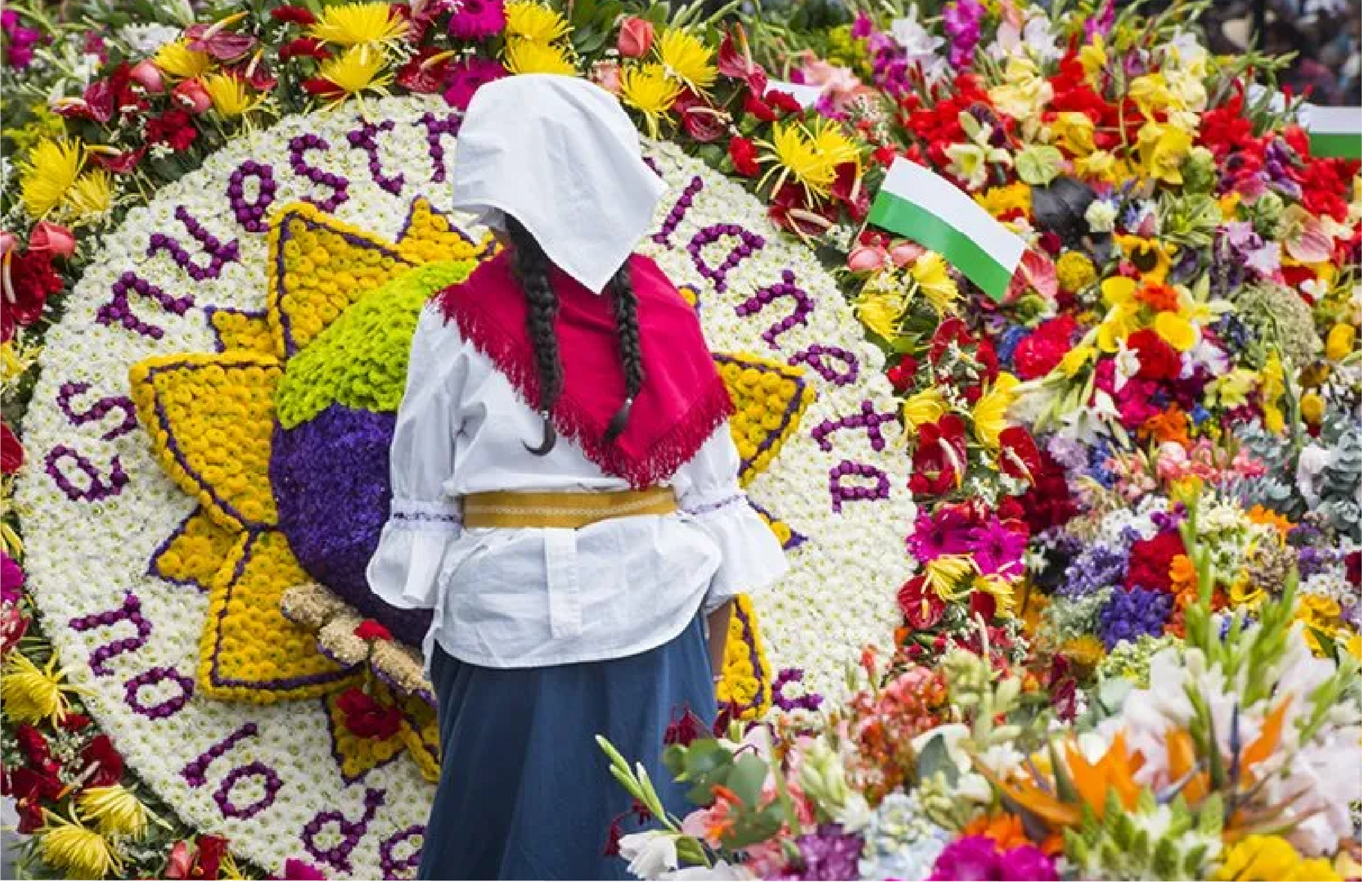 Una mujer está parada delante de una corona de flores la ceja antioquia.