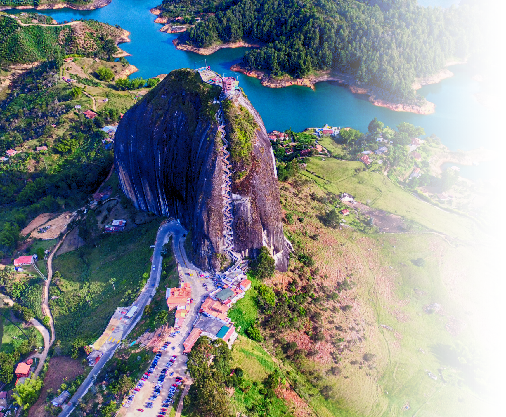 Una vista aérea de una montaña con un lago al fondo.