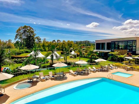 Una gran piscina con sombrillas y sillas alrededor hotel lagoon llanogrande