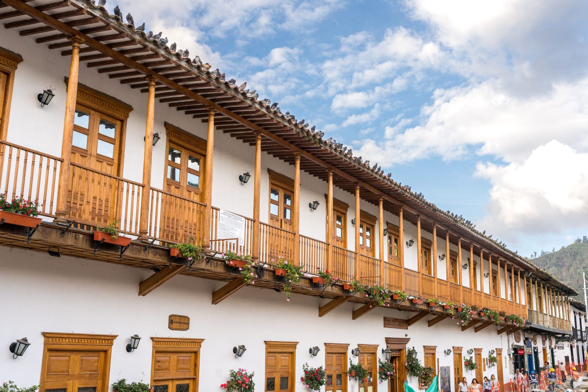 Un edificio blanco con balcones de madera en los laterales el retiro antioquia.