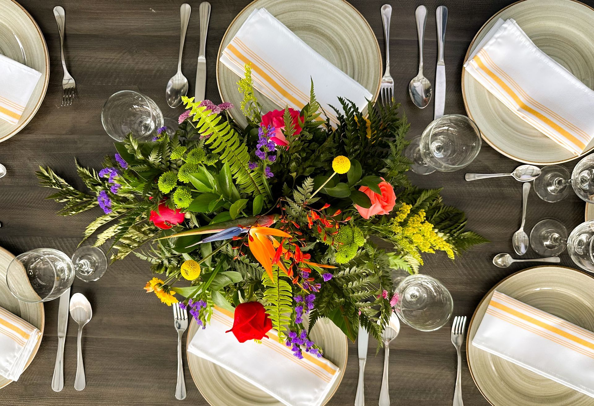 Una mesa dispuesta con platos, cubiertos y un ramo de flores en el centro hotel lagoon llanogrande.