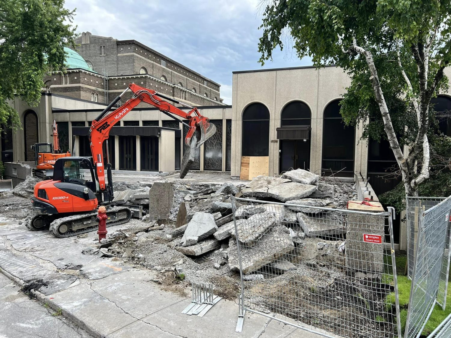 Vue intérieure d'un chantier de construction commerciale avec solives de plafond apparentes, charpente métallique et matériaux de construction.