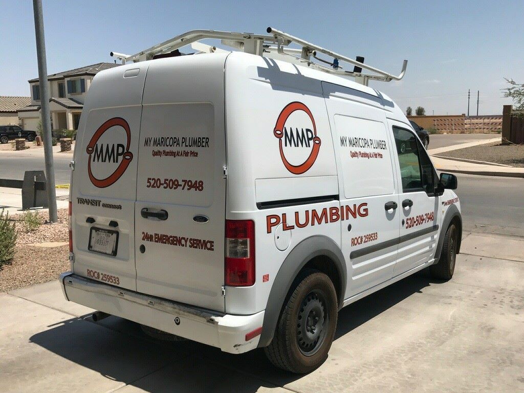 A man and a woman are sitting on a couch with a dog.