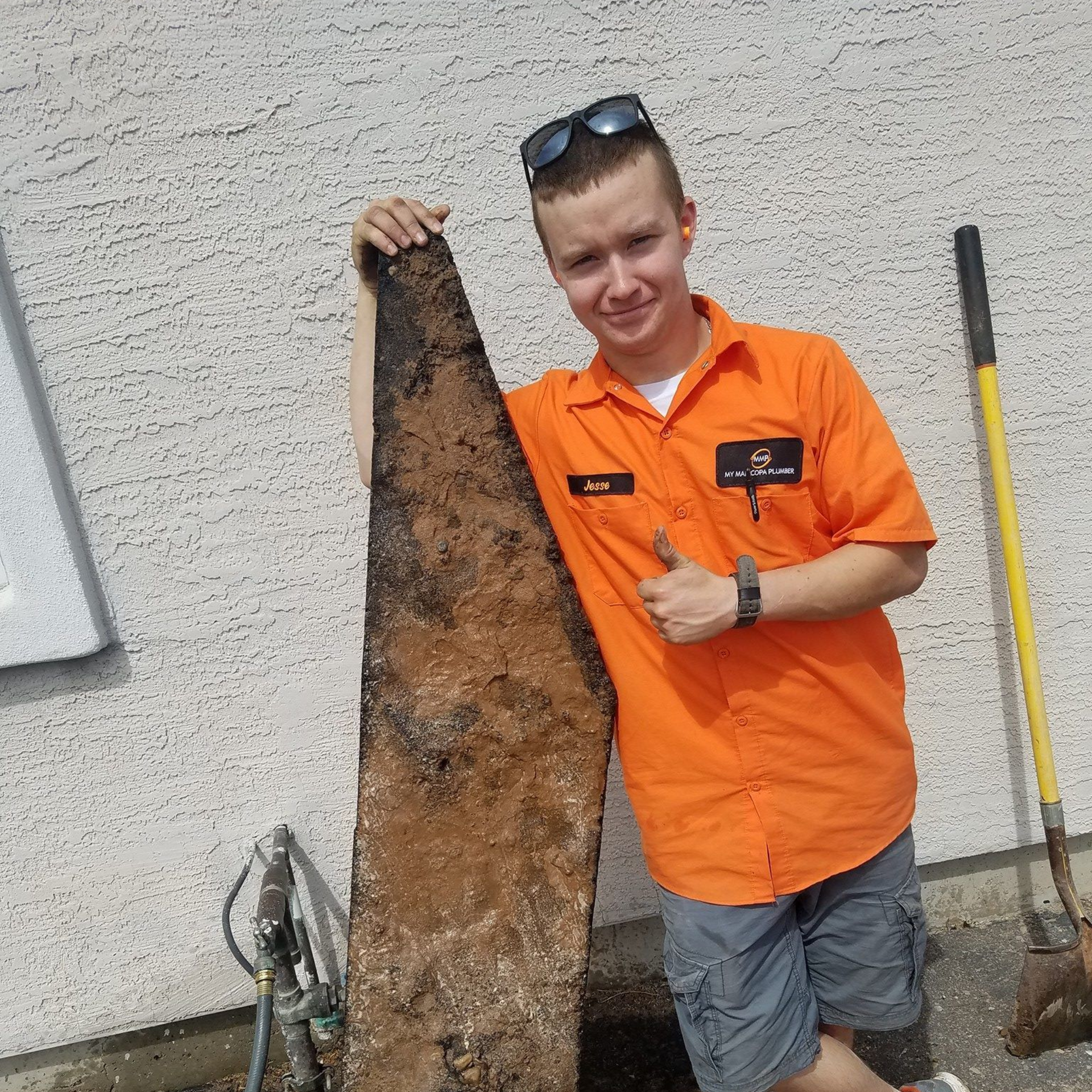 A man is working on an air conditioner on a balcony.