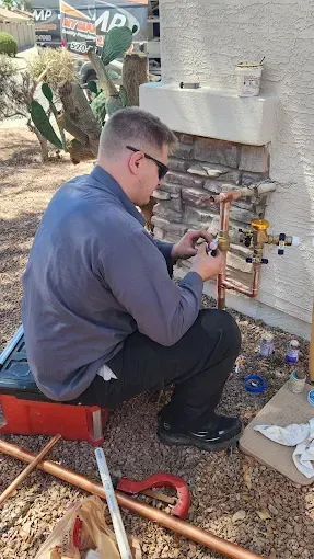 Three men are standing in front of a sign for bates mechanical inc.