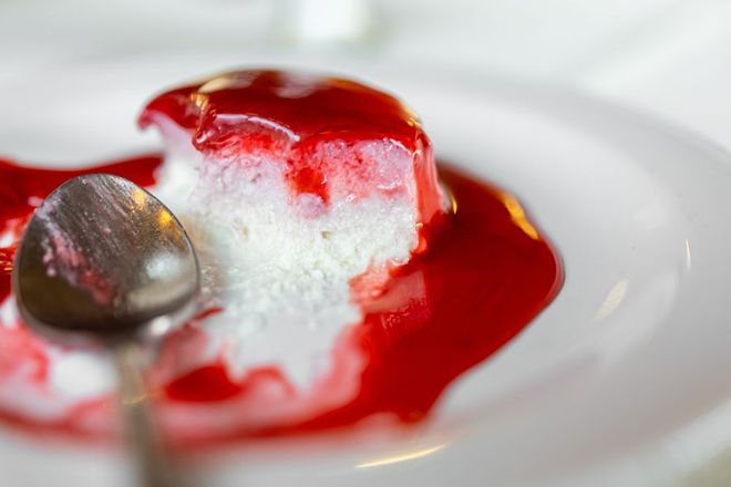 A close up of a dessert with a spoon on a plate.