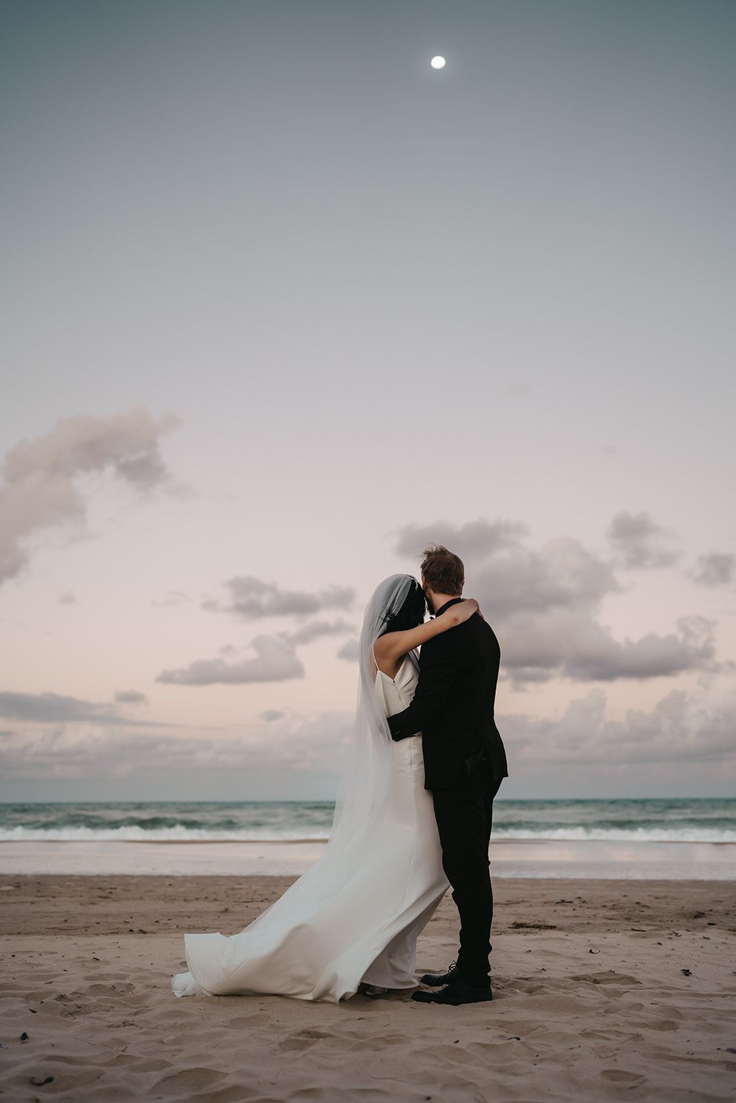 couple just eloped with feet in the ocean on Noosa beach