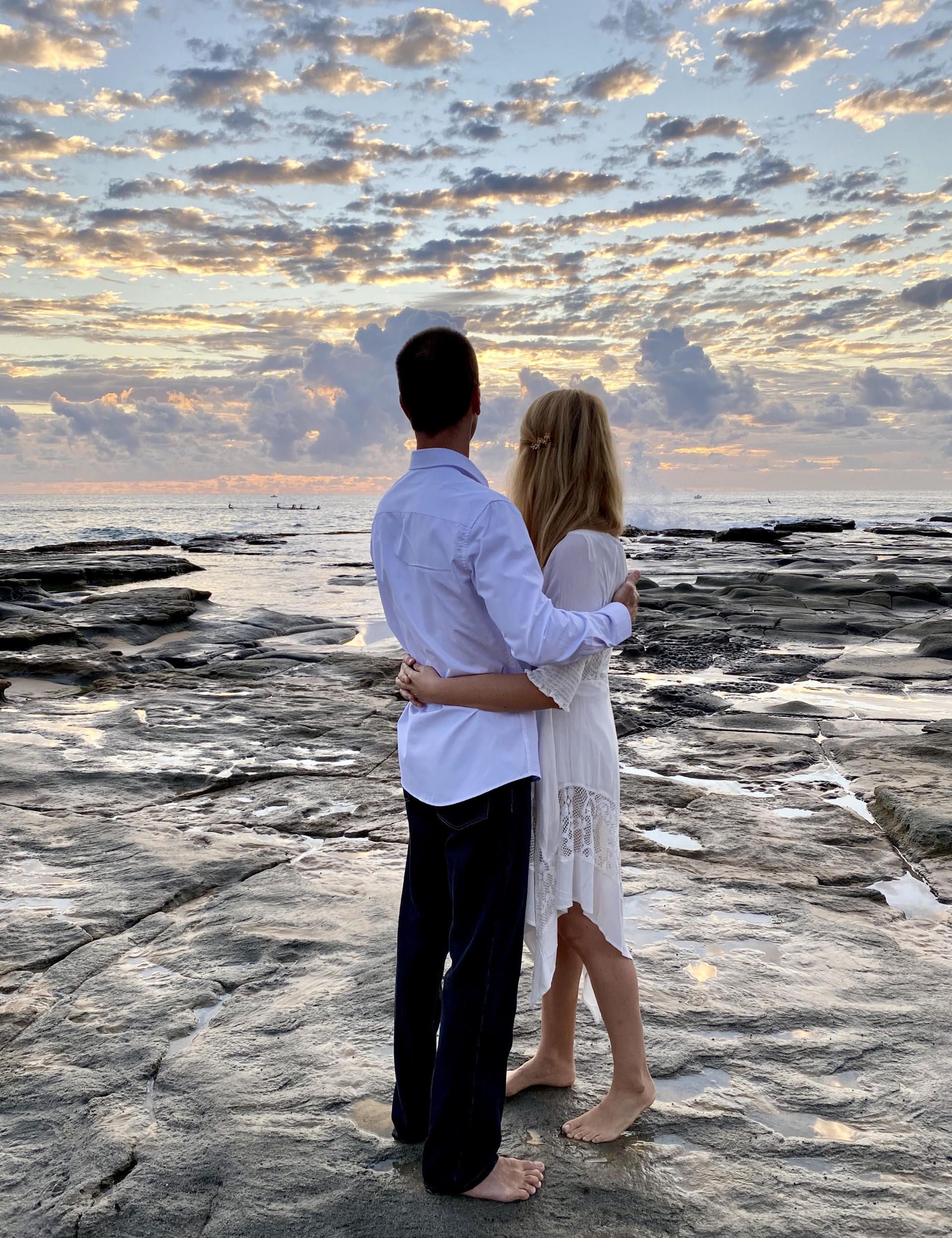 Elopement at Point Cartwright at Sunrise, couple looking towards daybreak and cuddling