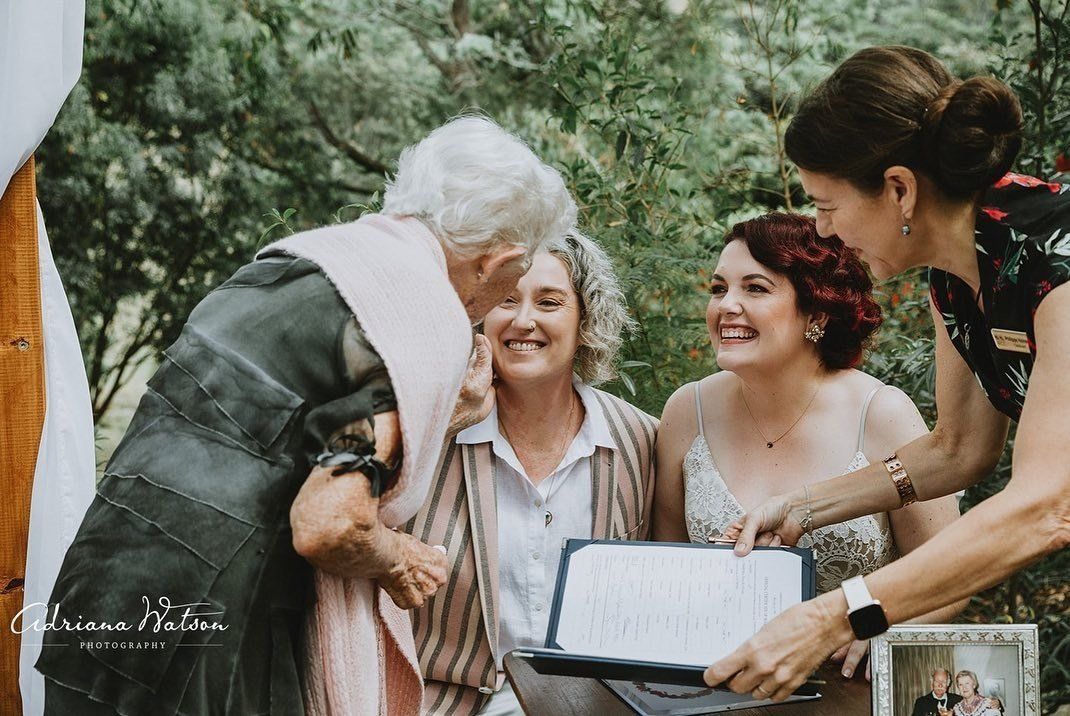 white haired grandma with scarg witnessinh her grandaughter sign marriage register after her same sex Noosa hinterland wedding
