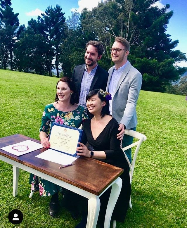 2 gay women in same sex wedding at Maleny retreat in the hinterland with their 2 boy witnesses. green grass all around