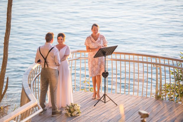 couple marrying on deck with flowers Buderim Noosa Wedding Celebrant