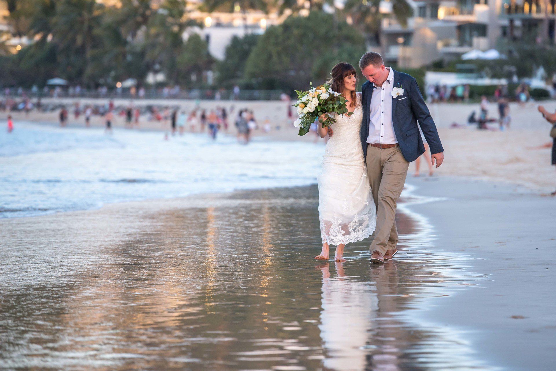 Noosa Elopement Main Beach Wedding Flowers, couple waking closely with feet in the water and Noosa Heads behind them