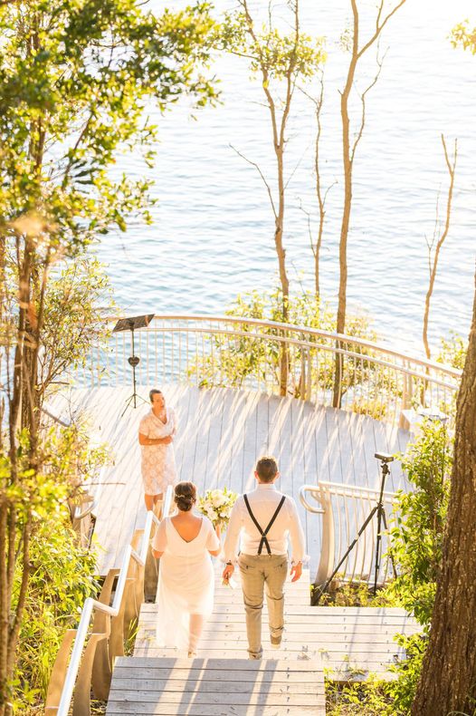 couple walking down boardwalk steps to their sunset elopement in noosa