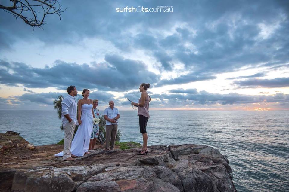 celebrant perched atop a mountain with couple eloping in Noosa with their parents at sunrise