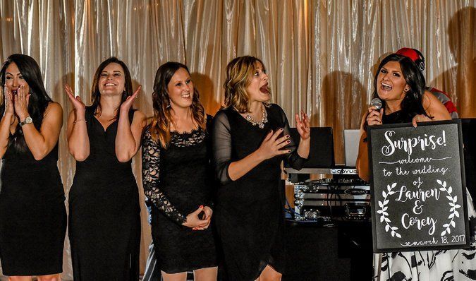 five pretty women in black and styled hair at surprise wedding with music and fun