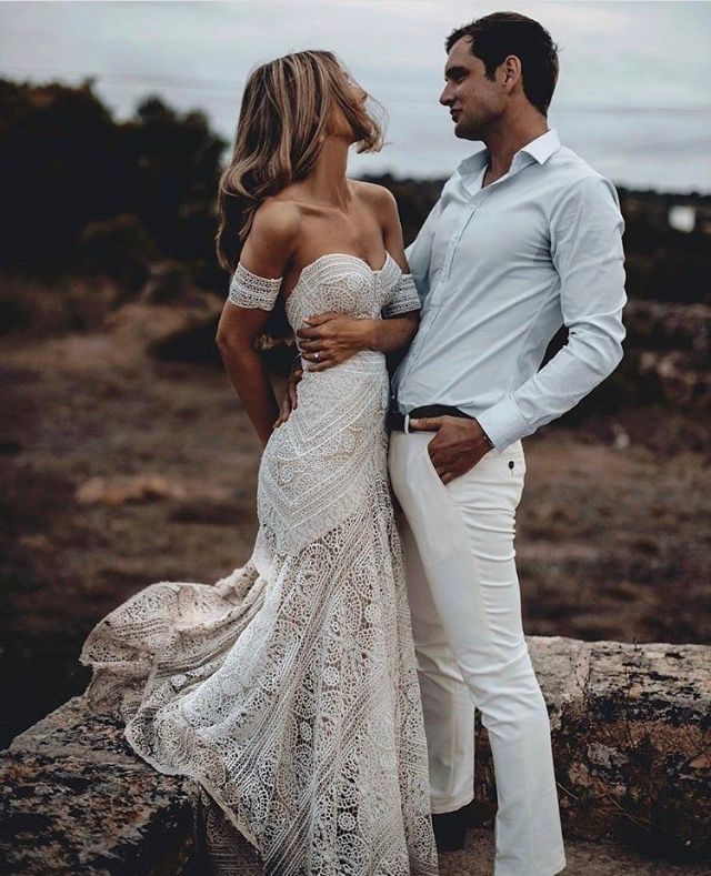 gorgeous couple dancing groom in white pants with hand in pocket, bride in tight white gown and long hair flowing