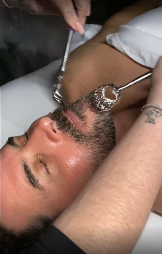 Man's beard being scratched with metal claw