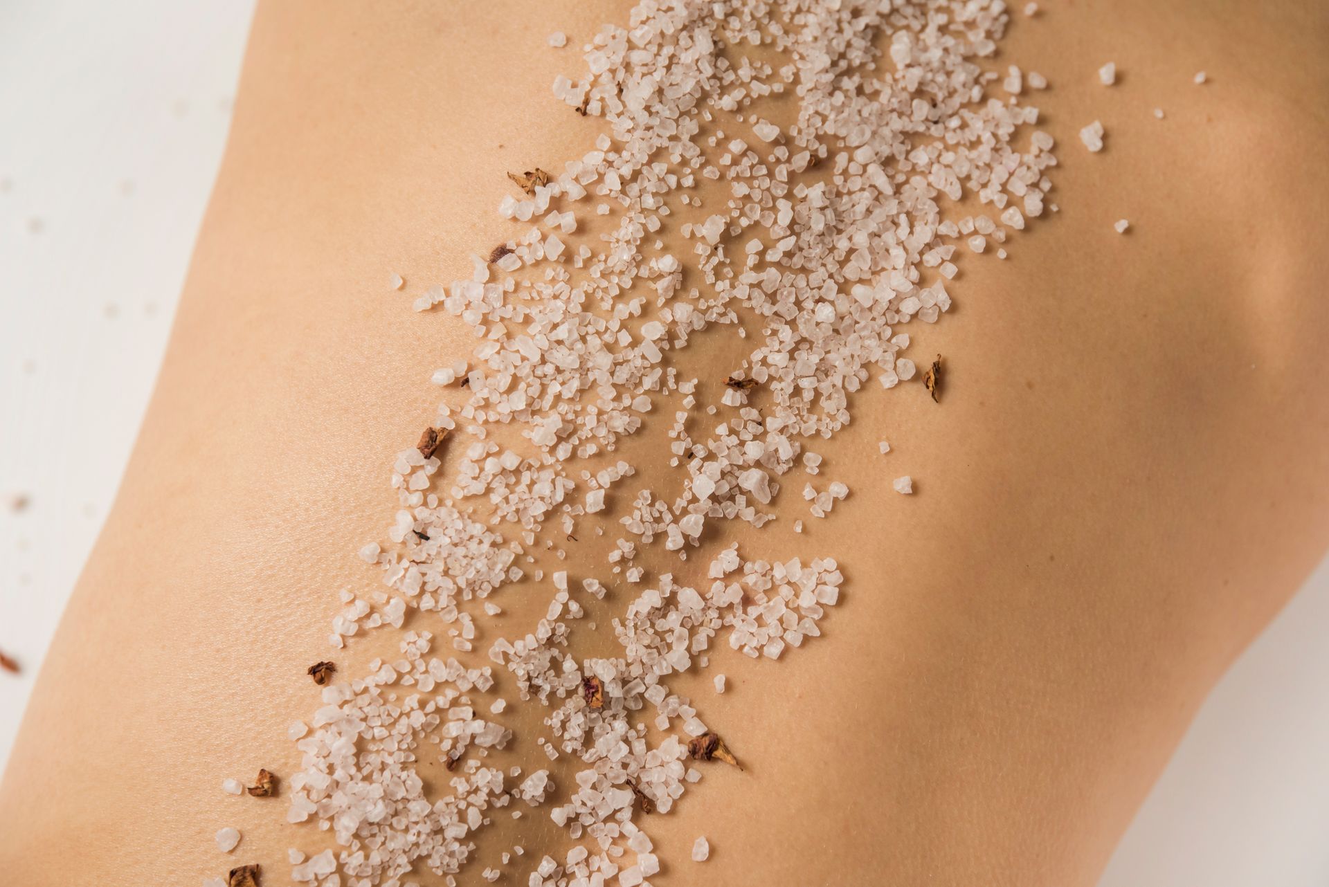 Body with salt scrub applied in a strip down the back.