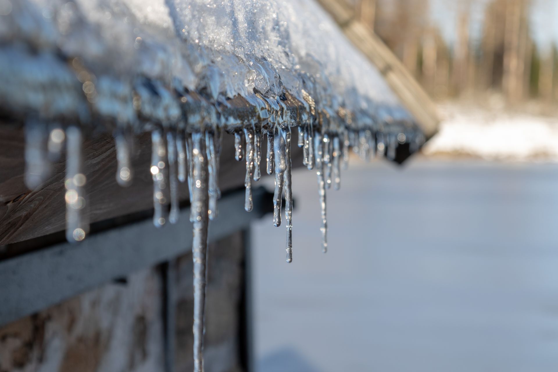 Icicles hanging from a snow-covered gutter during cold winter weather.