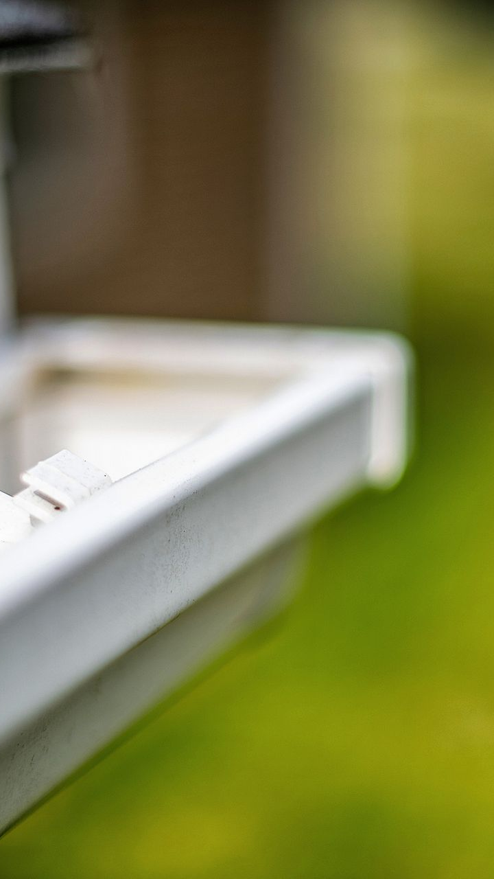 Close-up of the white, locked gutter of a home.