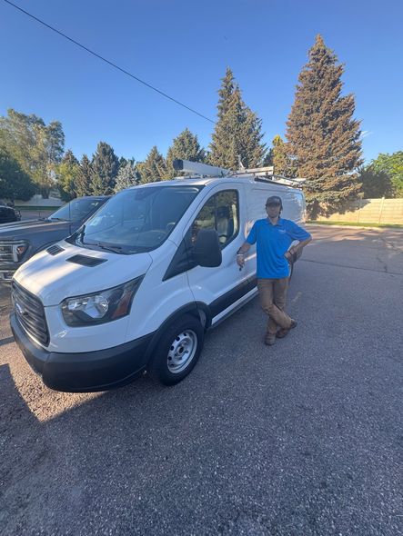 A man is standing in front of a white van.