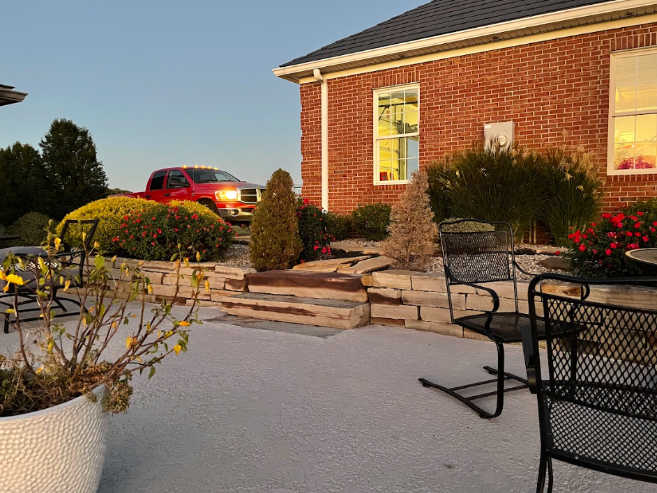 A man is kneeling down in a garden.