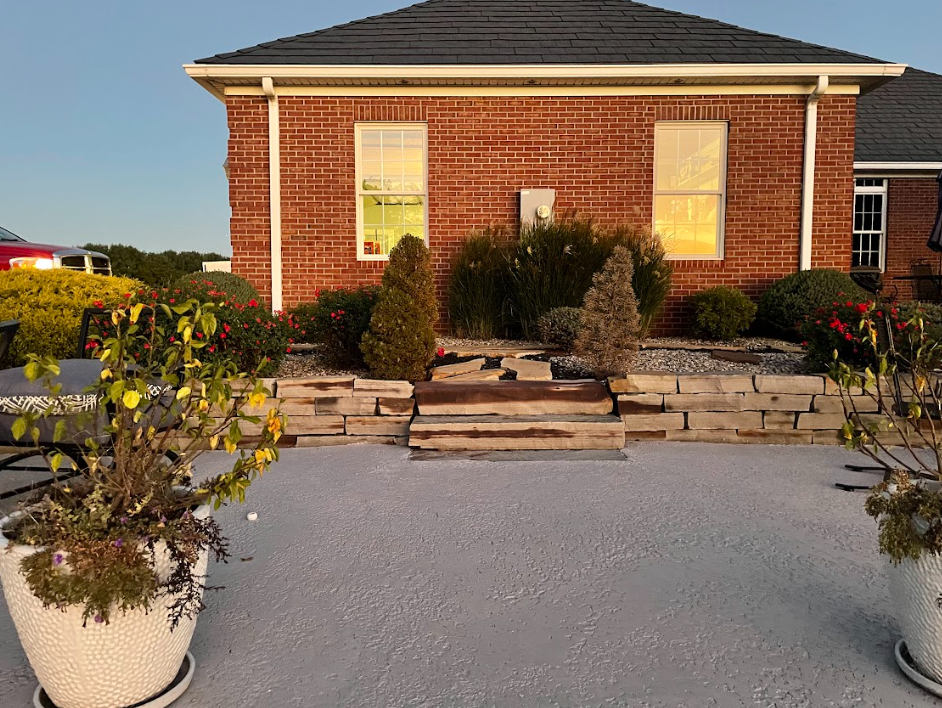 A man is kneeling down and laying bricks on the ground.