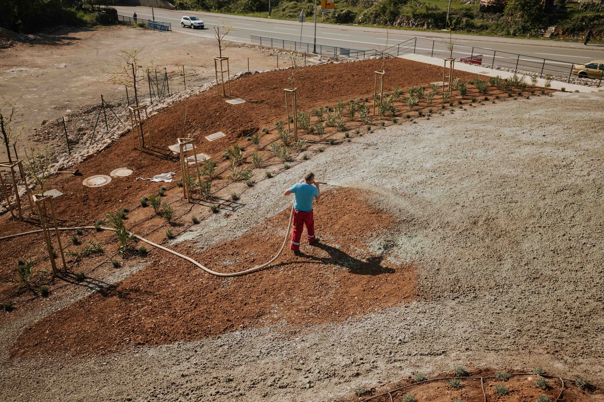 A man is standing in the middle of a gravel field.