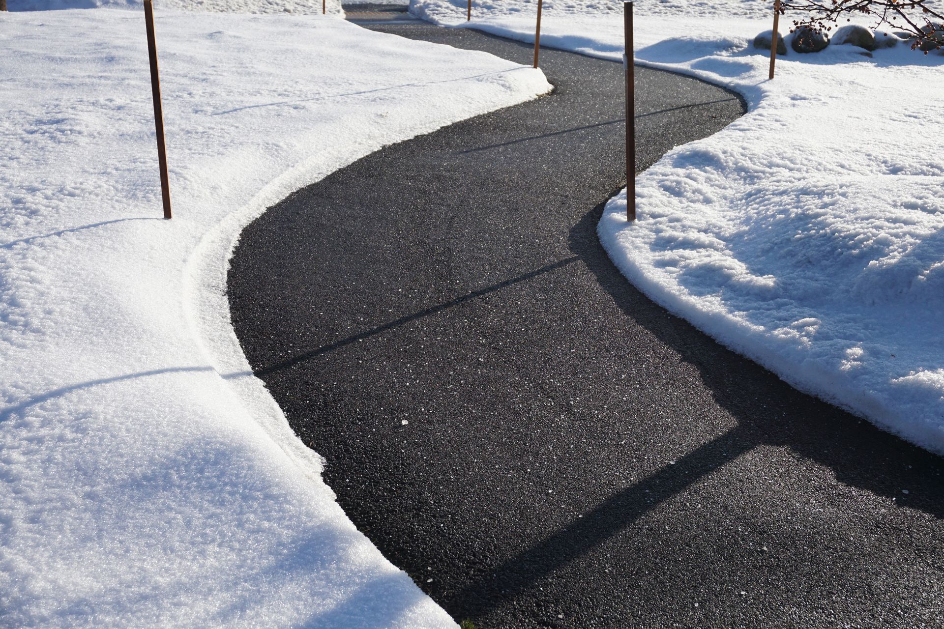 A walkway covered in snow on a sunny day