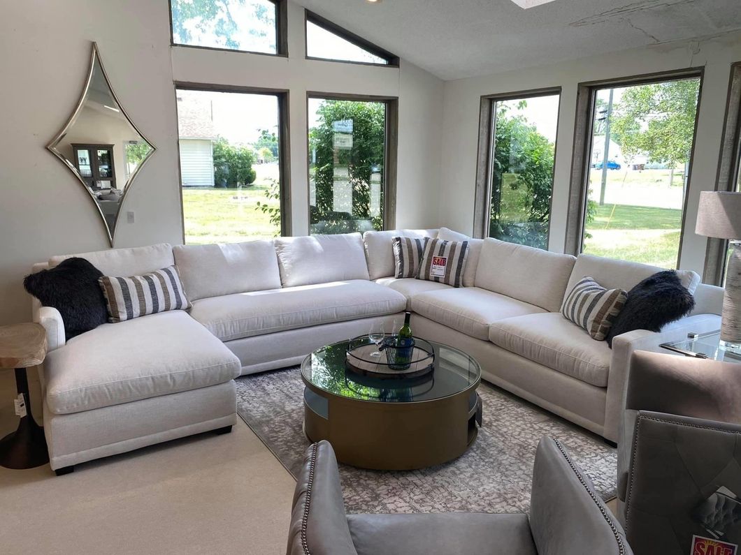 a living room with a large sectional couch and a round coffee table .
