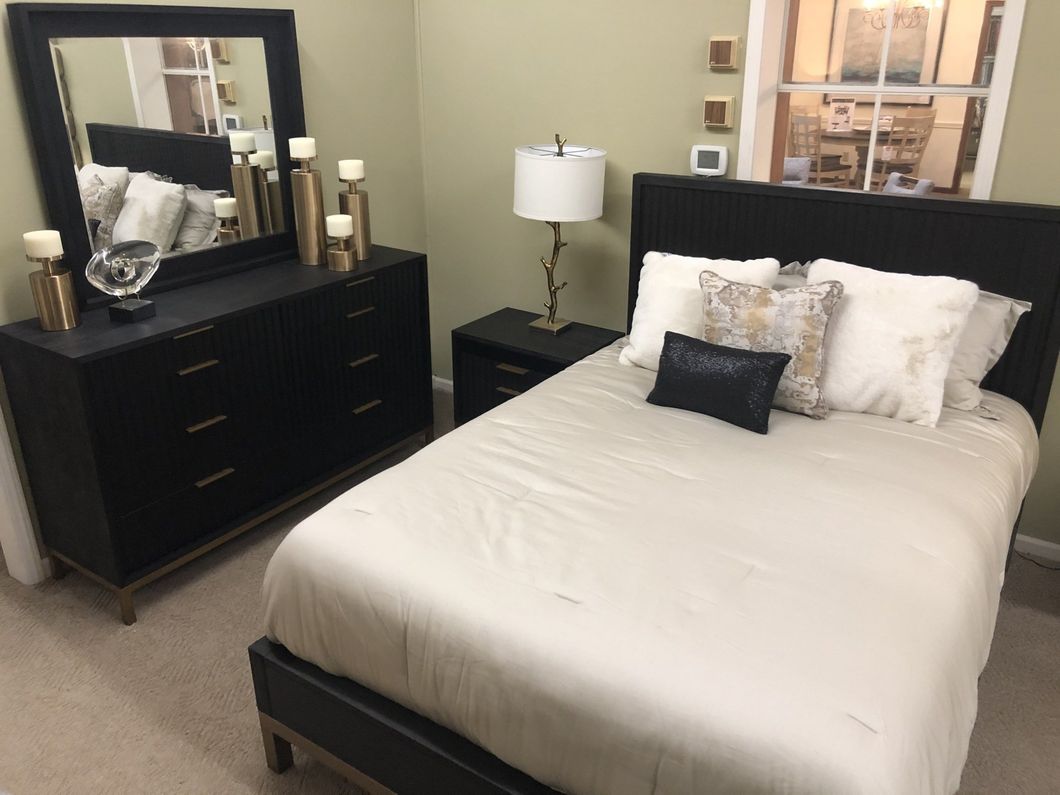 a bedroom with a bed dresser and mirror
