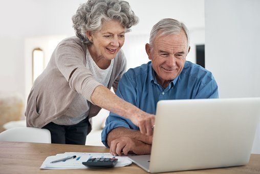mature adults filling out registration forms on the computer
