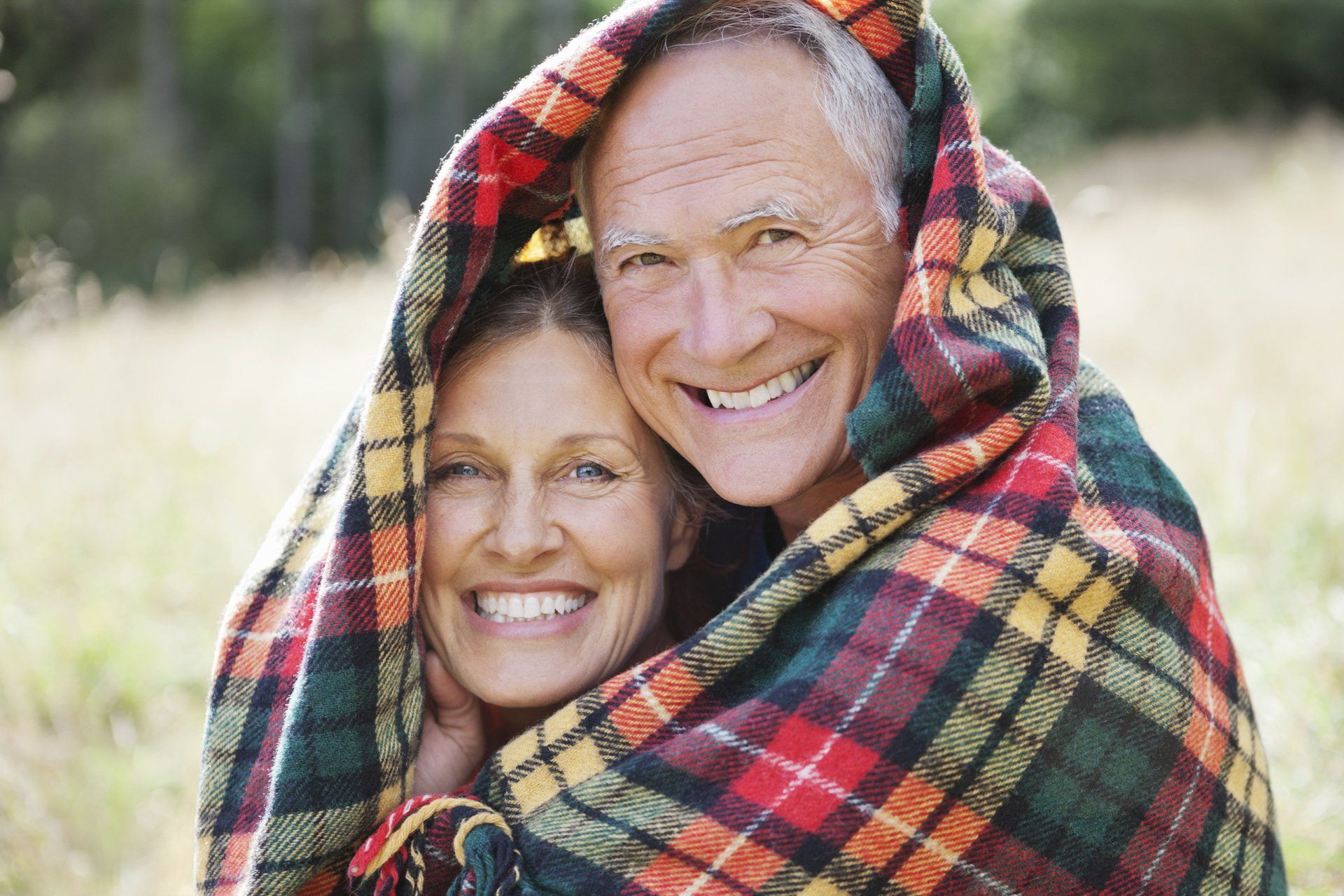 man and woman snuggled in blankets