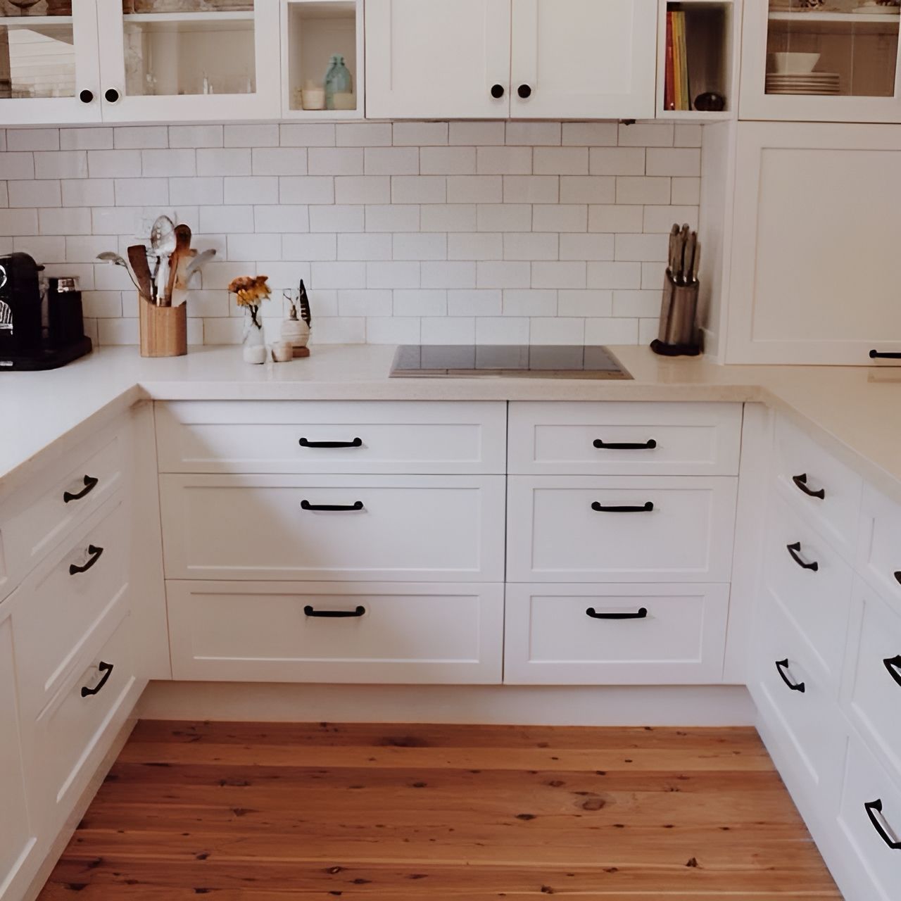A Kitchen With White Cabinets and Wooden Floors — Paiano Custom Kitchens In Corrimal, NSW