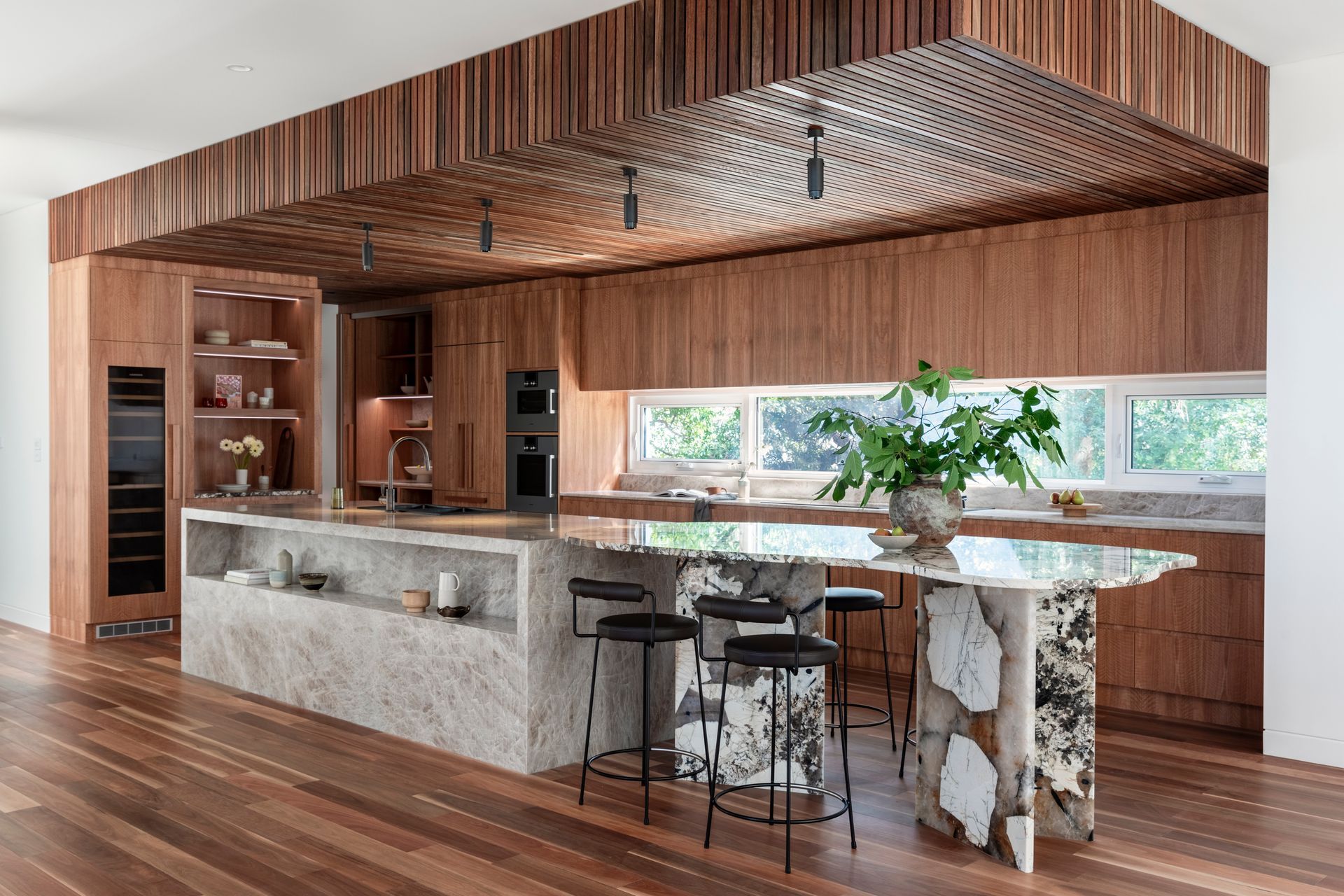 A Kitchen With a Large Island and Stools — Paiano Custom Kitchens In Corrimal, NSW